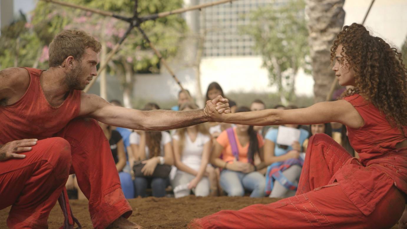 two dancers performing on dirt under a tent Vertigo dance company